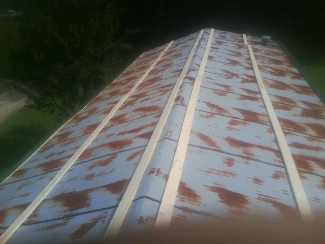 Rusted metal roof panels with new wood purlins before replacement — Storm Damage Roof Repair in Parsons by Roofing Brothers