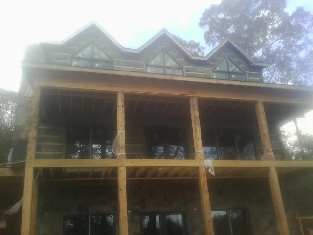 Dormers and porch framing on a large log home under construction in Parsons